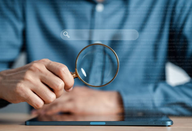 istock Businessman use magnifying glass Search On Virtual Screen Data Search Technology Search Engine Optimization. Man use tablet to Searching for information. Using Search Console for data. 1457132958