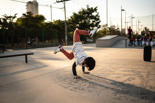 Child boy breakdancing at skateboard park