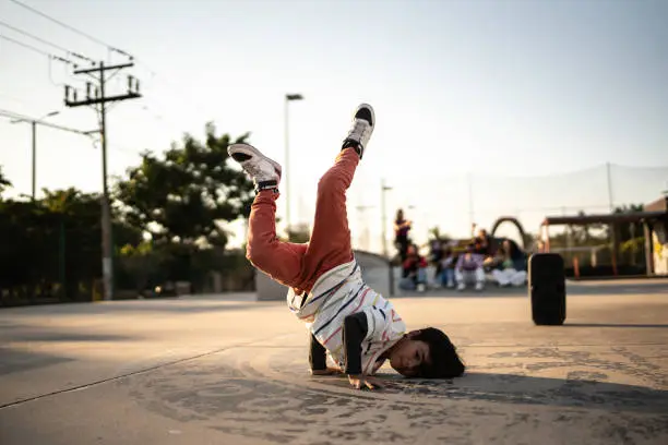 Photo of Portrait of child boy breakdancing at skateboard park