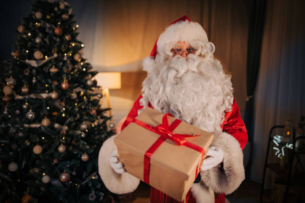 istock Santa Claus holding a present 1457137344