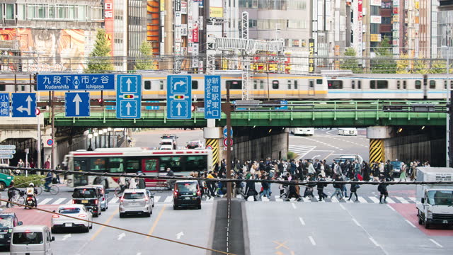 Car, bus traffic transportation on road intersection, subway train on elevated railroad track, Japanese people walk cross junction in Shinjuku district, Tokyo Japan. Asia transport, Asian city life.