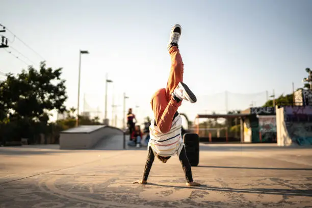 Photo of Child boy breakdancing at skateboard park