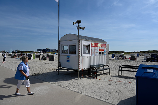 Norddeich, Lower Saxony, Germany, September 4, 2022 - Wooden hut of the DLRG, German Lifesaving Society, painted white, on the North Sea beach of Norddeich.