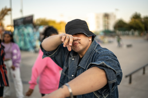 Portrait of young man dancing hip hop with her friends outdoors