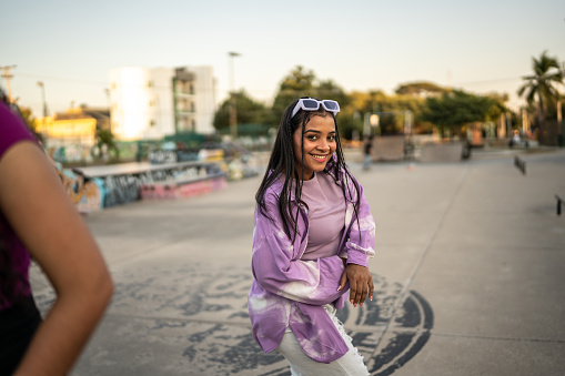 Portrait of young woman dancing hip hop at skateboard park