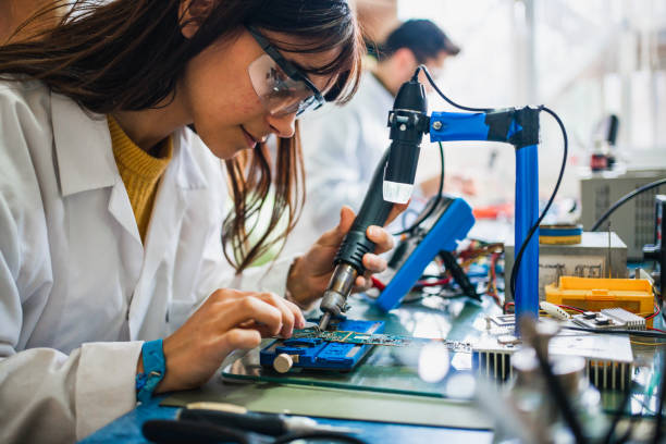 collègues travaillant sur un circuit imprimé au bureau - ingénieur photos et images de collection