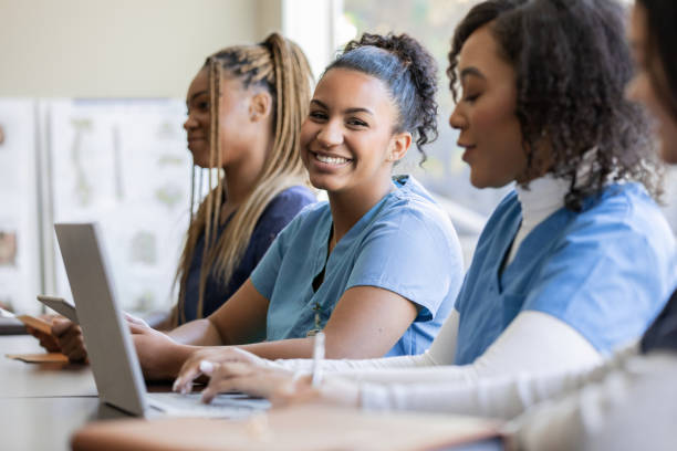 istock Young nurse or medical intern uses laptop computer with classmate during university training class 1457154792