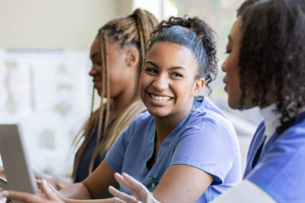 istock Young nurse or medical intern uses laptop computer with classmate during university training class 1457154793
