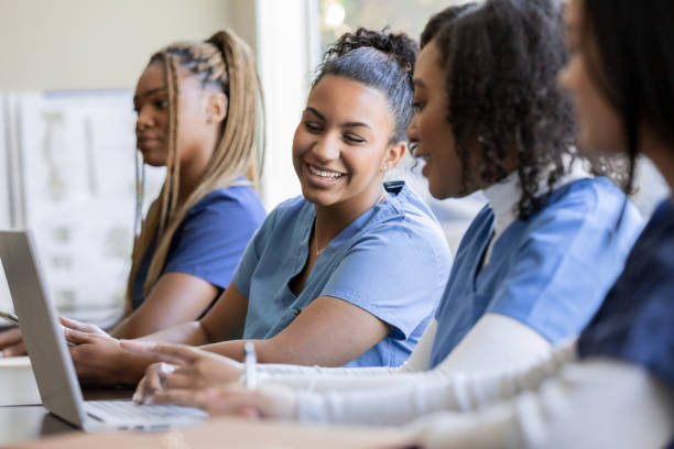 istock Young nurse or medical intern uses laptop computer with classmate during university training class 1457154824