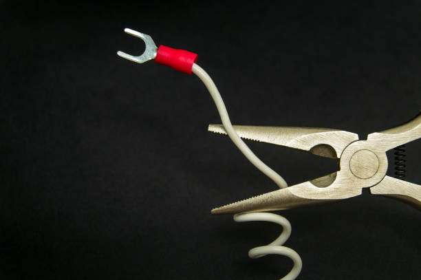 istock White wire with electrical terminal and round nose pliers on a dark background 1457154885