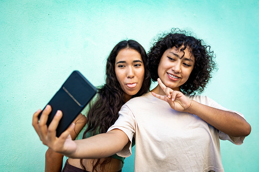 Two young woman taking selfie with a mobile phone