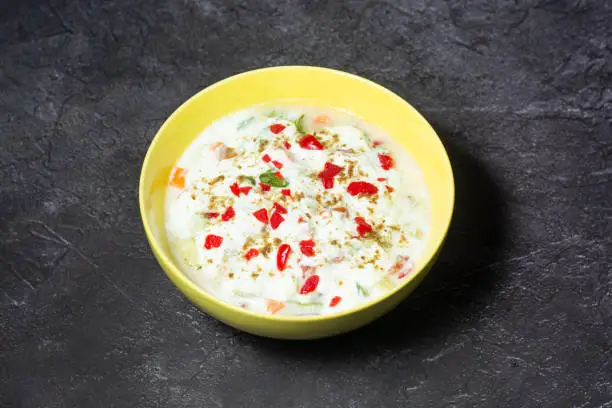Spicy Raita Vegetable, cucumber, mint and tomato served in dish isolated on grey background top view of indian and bangladesh food