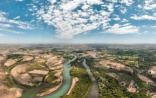 Panoramic aerial view of the city of Neuquen. To the left Limay river and to the right Neuquen river. The rivers begin to mix and you can see the different tonalities giving birth to Rio Negro river. Neuquen capital city, Patagonia Argentina