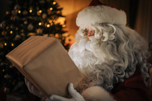 istock Santa Claus opening a present 1457160513