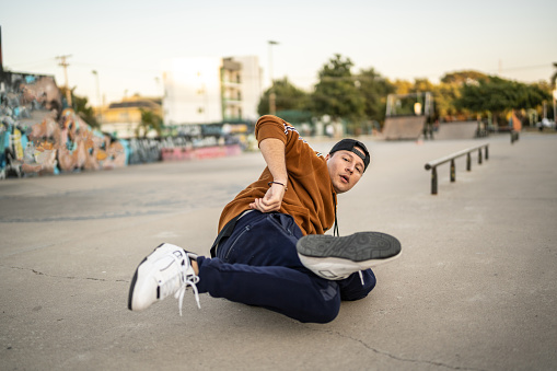 Portrait of young man breakdancing at skateboard park