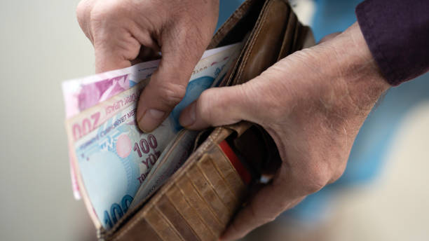 istock Hands holding and counting Turkish money 1457161010