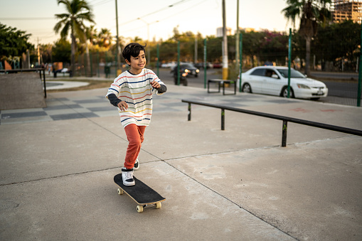 child boy skateboarding at skateboard park