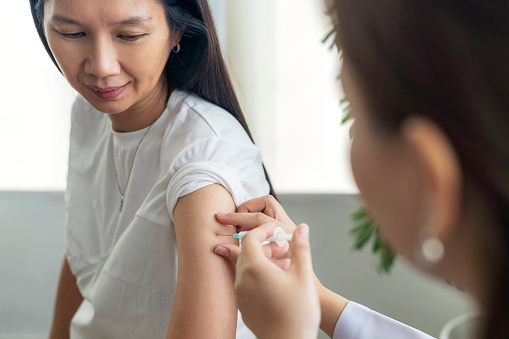 Close up of beautiful woman getting vaccinated in hospital