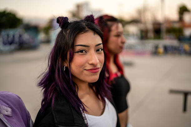 portrait d’une jeune femme marchant avec ses amis au skateboard park - mode de vie alternatif photos et images de collection