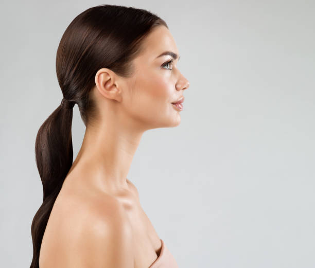 profil wajah sempurna model kecantikan. wanita brunette dengan kulit wajah halus yang sehat dan rambut di atas putih. potret cantik girl side view dengan bibir penuh dan make up natural. operasi plastik wanita - foto-profil potret stok, foto, & gambar bebas royalti