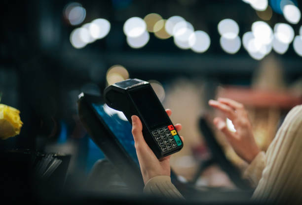 istock Hands holding a credit card reading machine 1457172763
