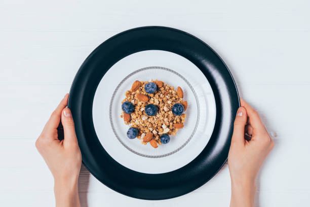istock Woman's hands hold a breakfast plate of granola 1457173649