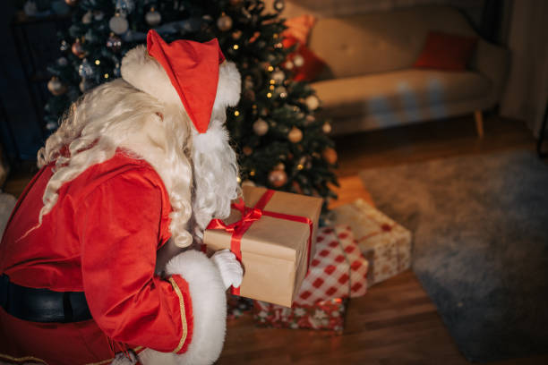 istock Santa Claus holding a present 1457176922