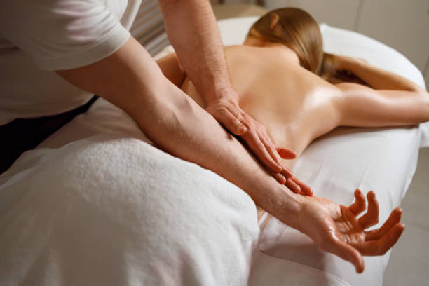 istock Man massaging woman's back in spa salon 1457179250