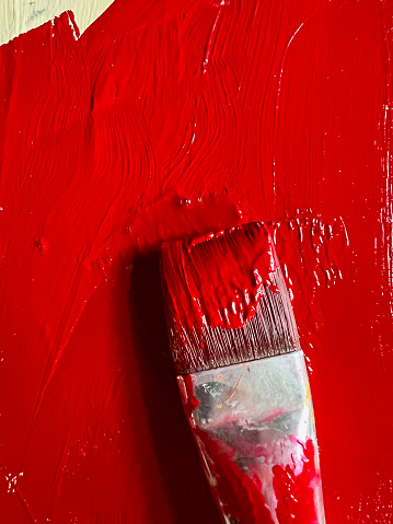 Red paintbrush in red paint