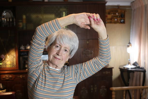 istock Senior woman stretching at home 1457179603