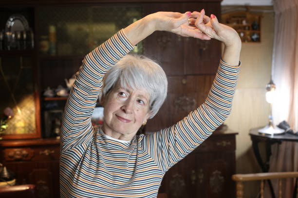 istock Senior woman stretching at home 1457179688