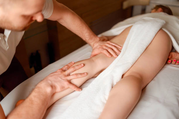 istock Masseur massaging woman's leg in spa salon 1457179928