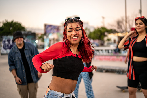 Young woman dancing hip hop during street party with her friends
