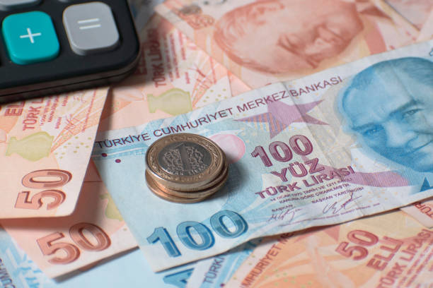 notas e moedas turcas na mesa com calculadora - minimum wage - fotografias e filmes do acervo