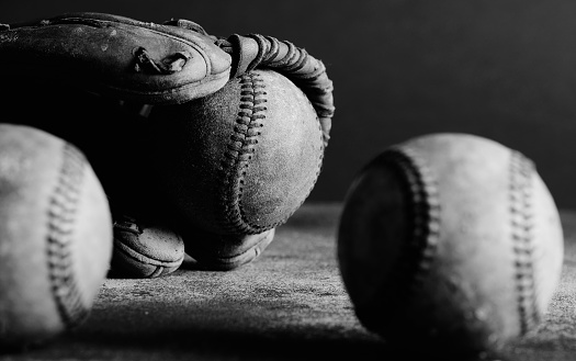 Old used baseballs in sports glove closeup