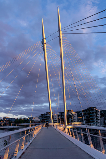 Cable-stayed bridge with pedestrian walkway illuminated by sunset light