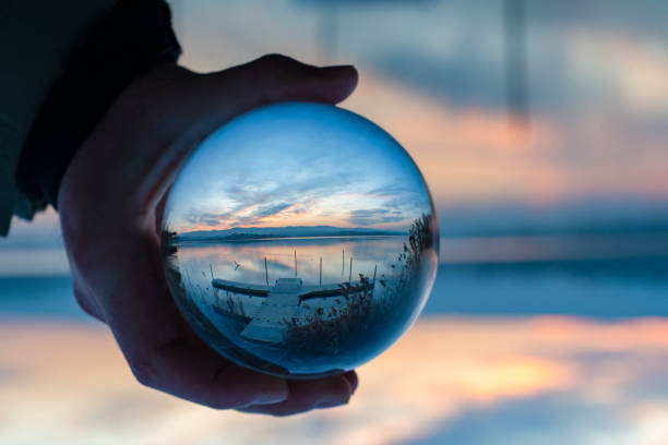 Man Holding Crystal Ball With Reflection Of Lake