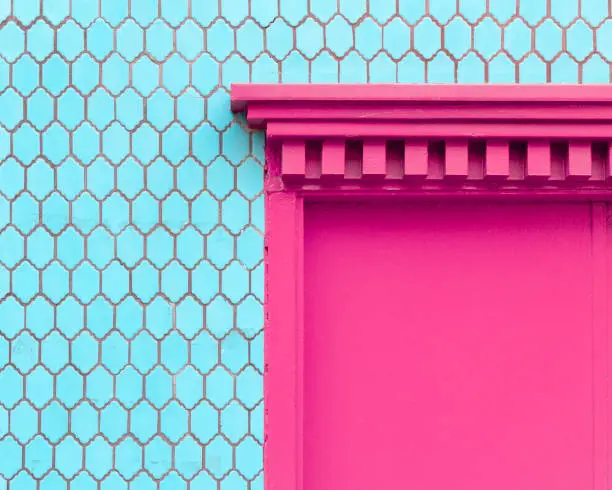 Turquoise blue tile wall with a hot magenta pink door entryway in Chinatown San Francisco, California.