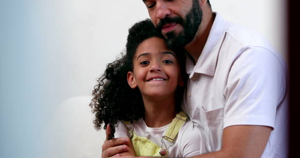 Father and daughter love. Mixed race child with dad hug and embrace stock photo