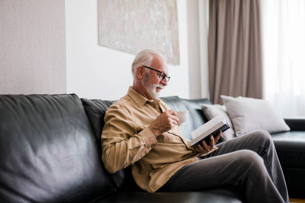 istock Senior man resting at home, drinking coffee and reading book 1457190429