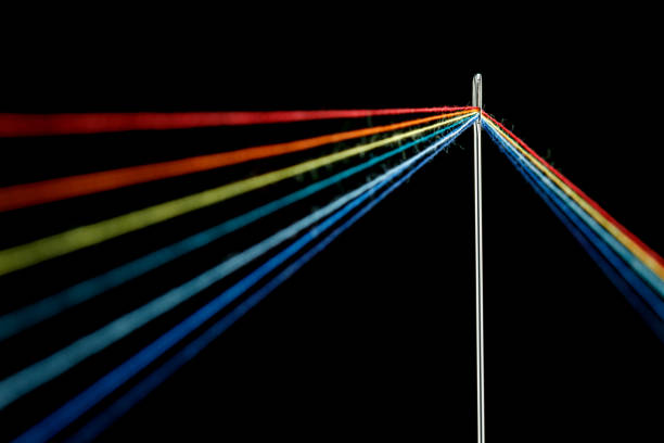 istock multi-colored threads for sewing in the form of a rainbow pass through an antique needle on a black background 1457191091