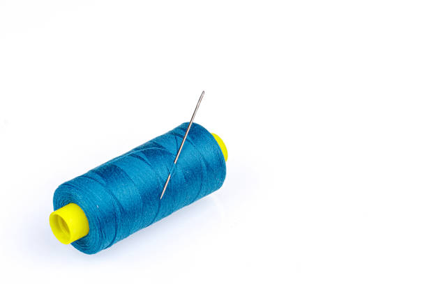 istock Macro skein of blue thread with a needle on a white background 1457191736
