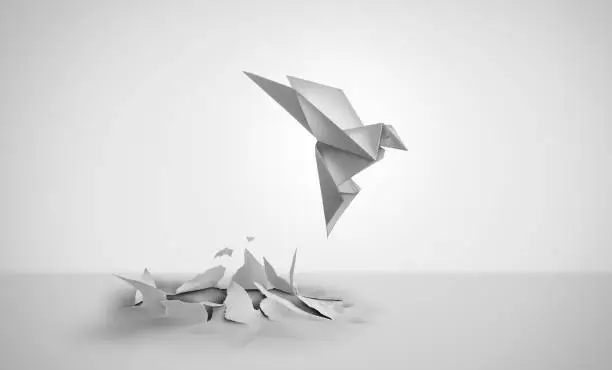 Out Of Nowhere concept of birth or rebirth as an origami bird emerging from a flat paper from scratch as a symbol of creativity and metamorphosis as a business success and an icon of change and transformation
