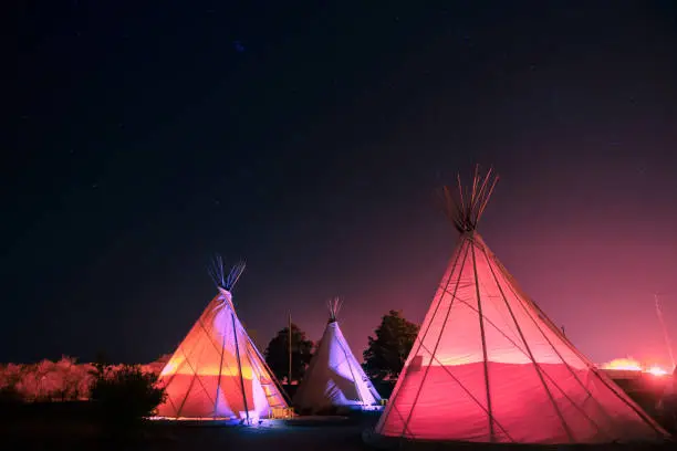 Three teepees glowing at night in the West Texas town of Marfa, Texas, USA.