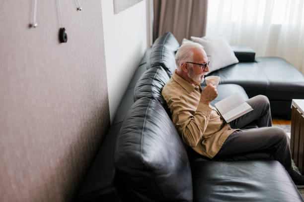 istock Senior man resting at home, drinking coffee and reading book 1457194652