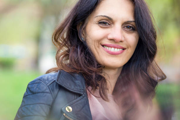 istock Beautiful middle-age woman in black leather jacket smiling broadly 1457196198
