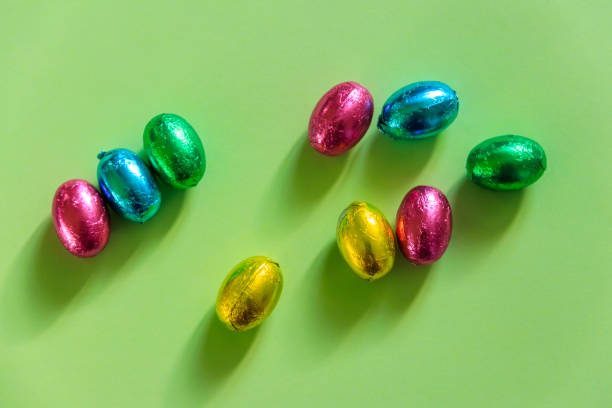 istock Easter chocolate eggs in foil on green background. Top view 1457198455
