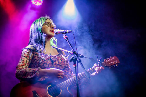 La tua cantante e chitarrista donna che esegue un concerto dal vivo - foto stock