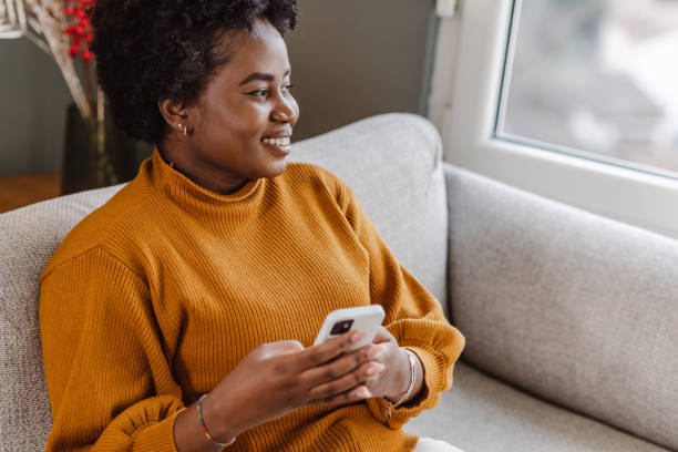 istock A young African-American woman using a mobile phone at home 1457203148