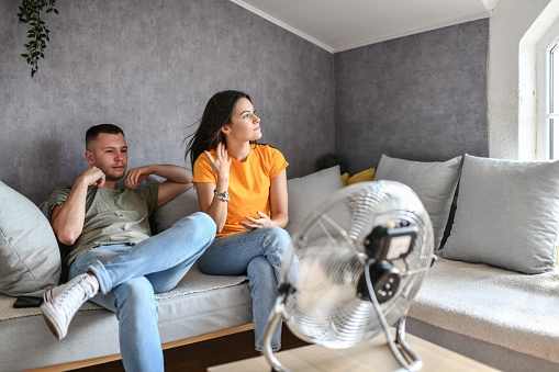 Hot Summer Days Making Couple Use Fan At Home